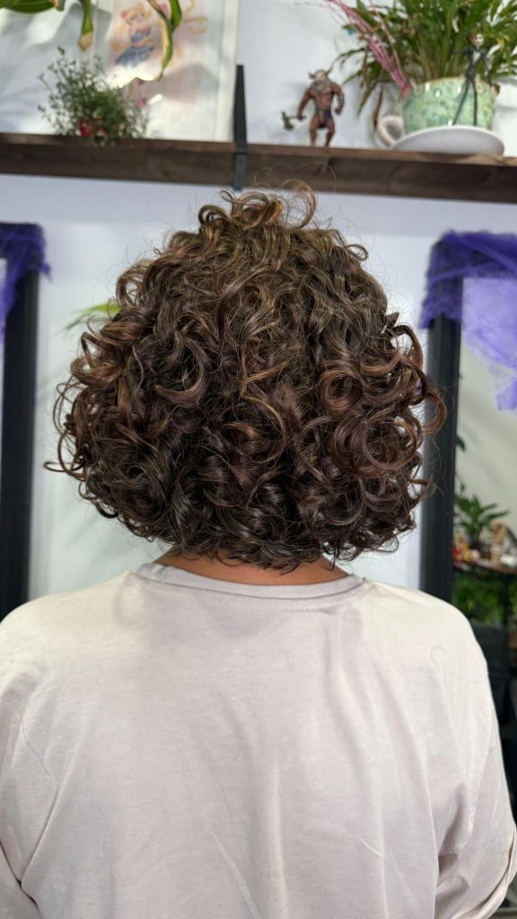 Cabello tratado con coloración vegetal - rizos definidos con tonos naturales marrones y reflejos castaños